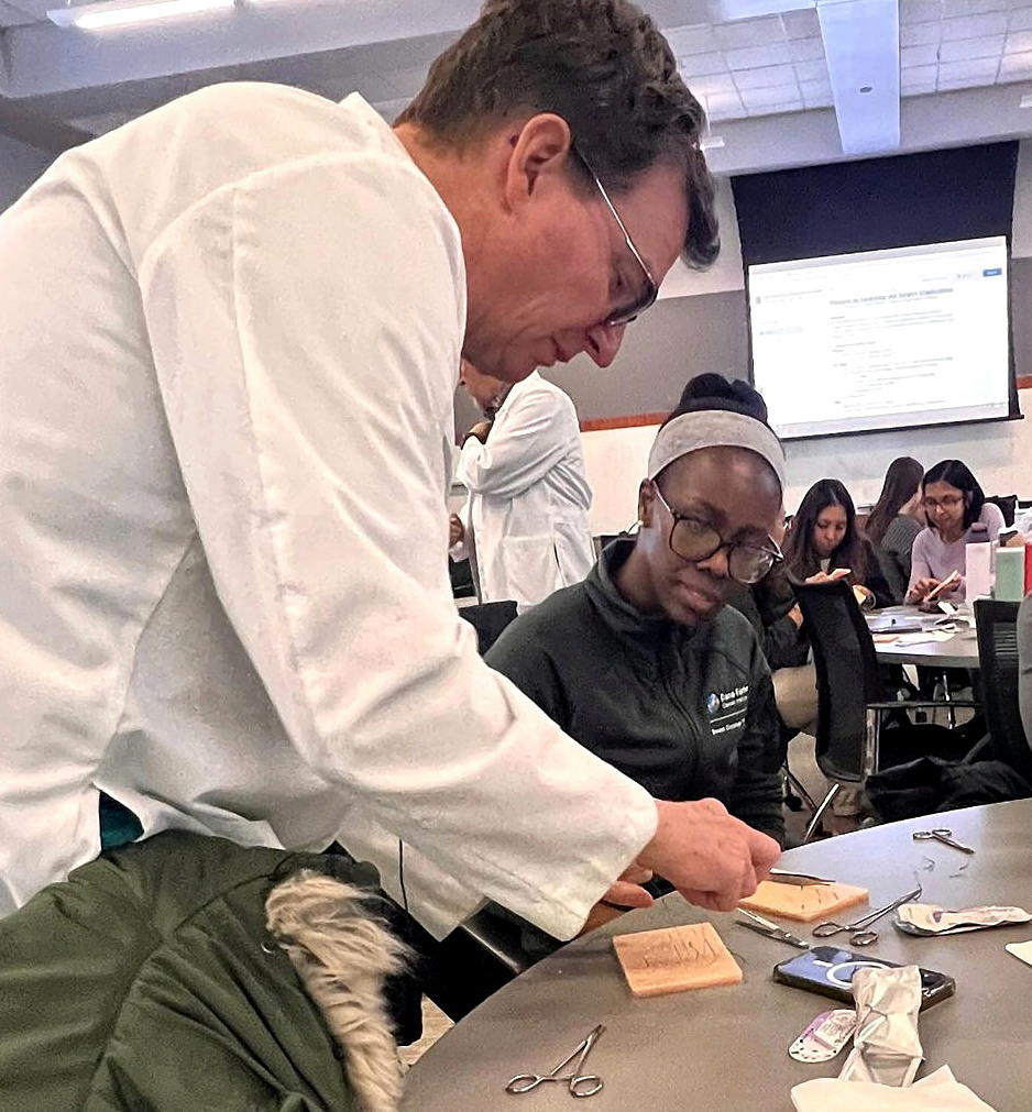 A surgical educator demonstrating suturing technique at a previous hands-on workshop